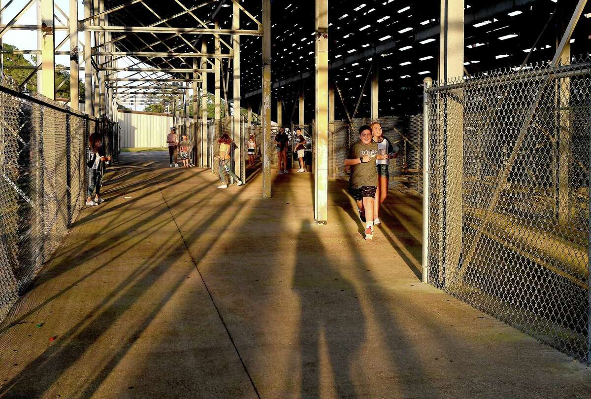 Kids play tag beneath the bleachers asVidor faces Buna at home in their season opening scrimmage. Photo made Friday, August 13, 2021 Kim Brent/The Enterprise