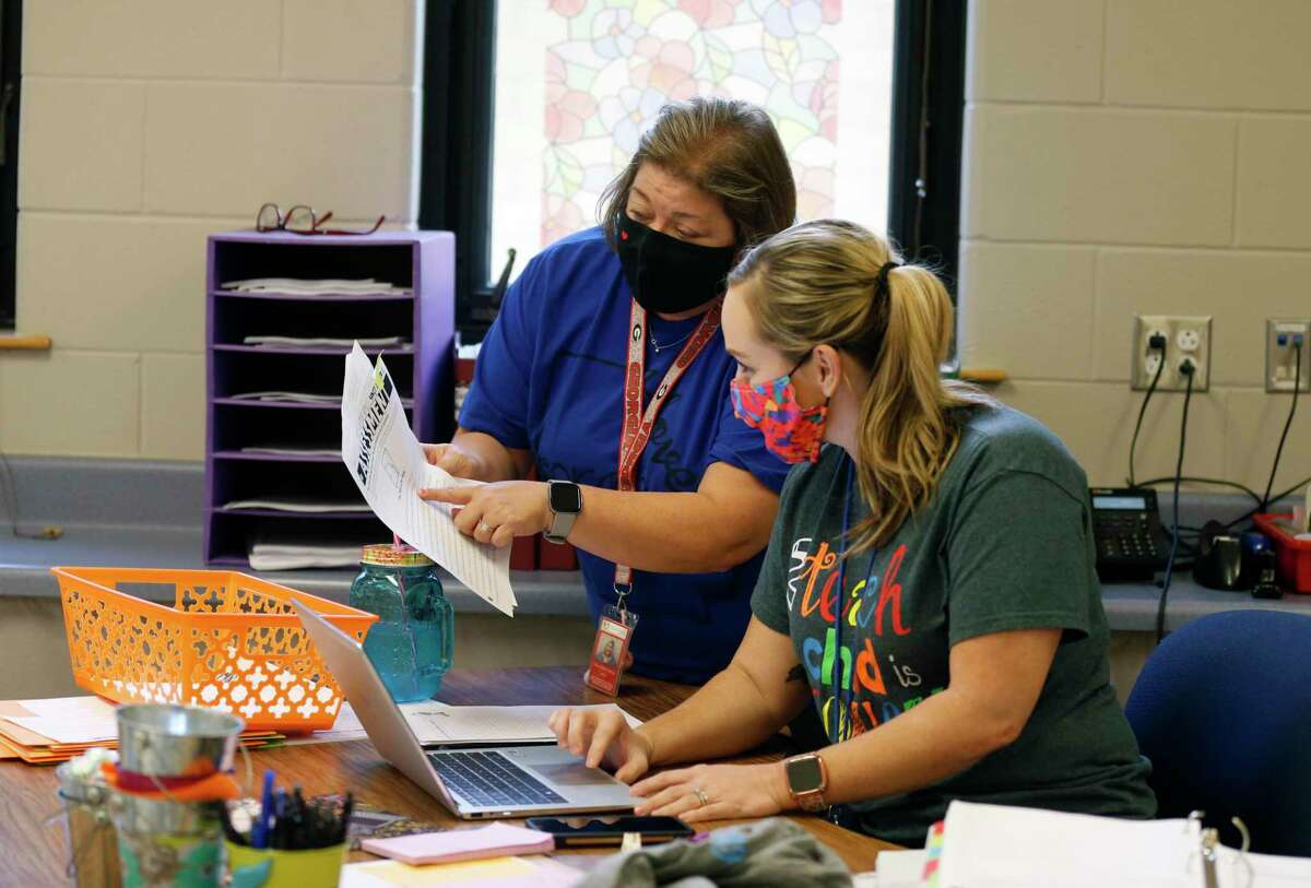 Allison Martino and Joy Crawford go over plans Friday for the first day of school at Lackland ISD, set for Monday. Students at the three school districts on Joint Base San Antonio will stay masked regardless of the outcome of a court battle between local and state officials.