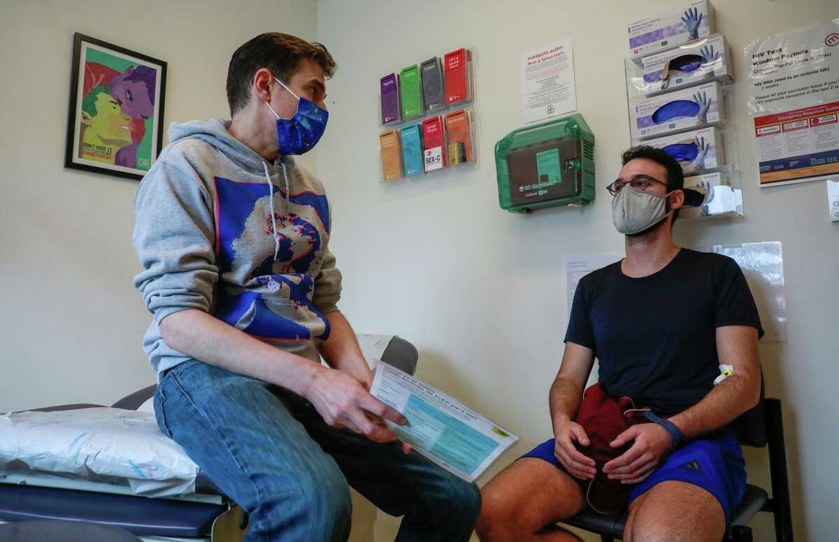 Nurse practitioner and HIV specialist Jonathan Van Nuys (left) discusses a medication with patient Ben Perlman.