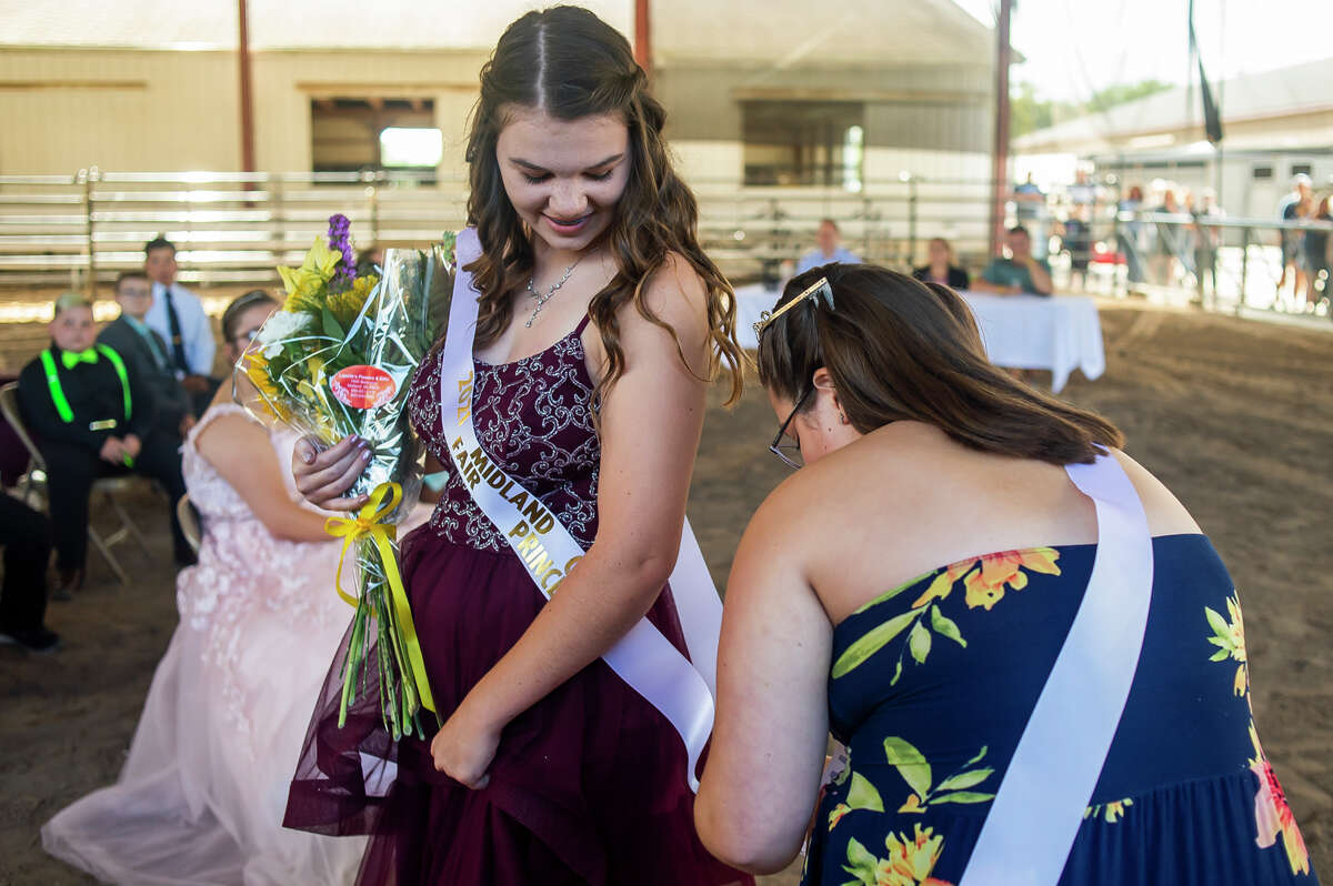 Rebecca Nohel, 13, left, is given her tiara and sash by Madison Crawford, the 2019 Midland County Fair Princess, right, after Nohel was named Princess in the 2021 Midland County Fair Royalty Contest Saturday, Aug. 14, 2021 at the Midland County Fairgrounds. (Katy Kildee/kkildee@mdn.net)