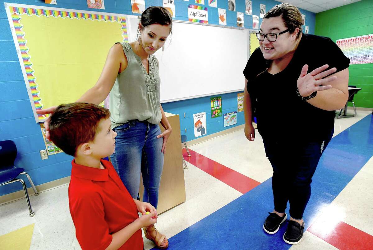 Kaylee Redkey greets incoming student Daniel Godeaux as his mother Shae looks on during a "Meet the Teacher" event for kindergarten through second grade students at Sallie Curtis Elementary School. Photo made Thursday, August 12, 2021 Kim Brent/The Enterprise