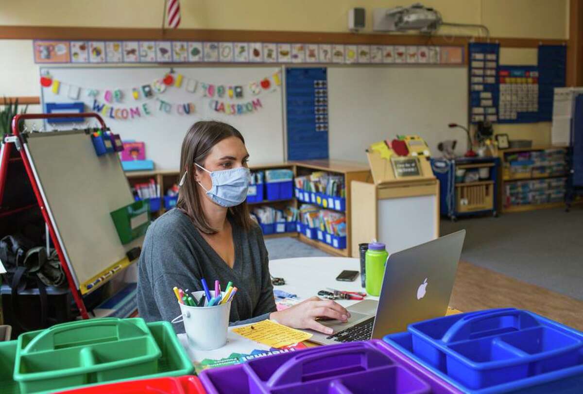 Kindergarten teacher Lauren Goss prepares her classroom before John Muir Elementary reopens after the shutdown.