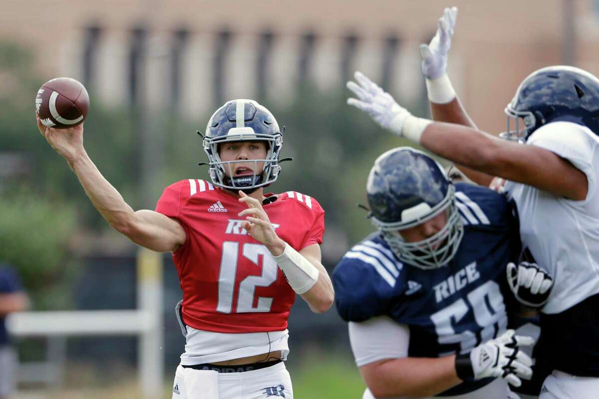 Quarterback Luke McCaffrey, left, passes the ball as Shea Baker (58) blocks Elijah Garcia, right, during a Rice football scrimmage on the practice field Saturday, Aug. 14, 2021 in Houston, TX.