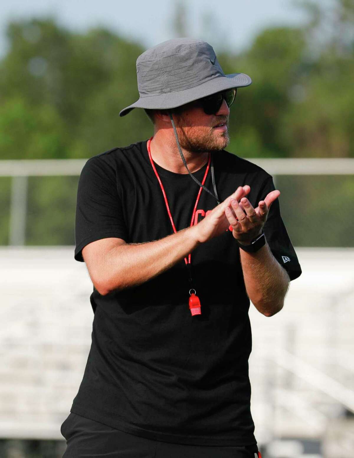Caney Creek head coach Kendall Hineman encourages players during football practice at Caney Creek High School, Tuesday, Aug. 3, 2021, in Conroe.