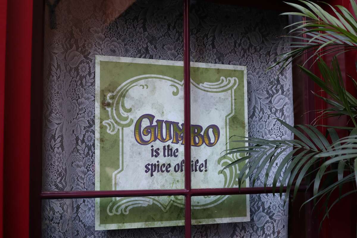 Signs in the window of Le Bat en Rouge in Disneyland's New Orleans Square.