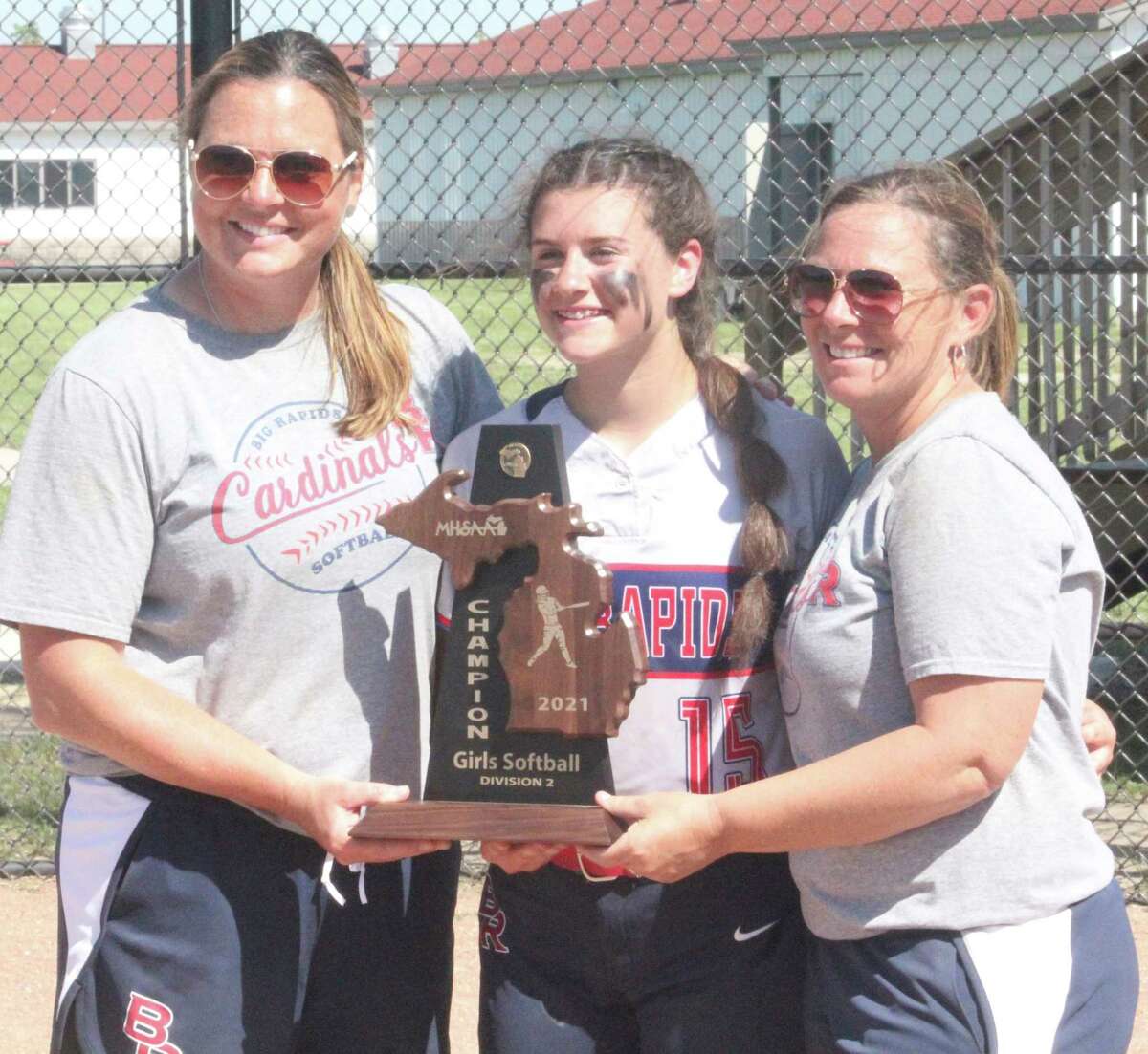 Big Rapids' Alanah Thompson holds the Cardinal district championship trophy in June with coach Dawn Thompson and assistant coach Jenny Prince (left). (Pioneer file photo)