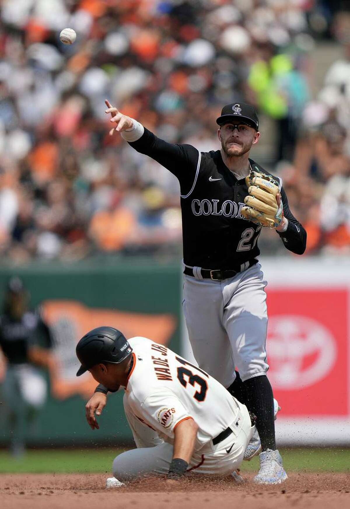 SAN FRANCISCO, CALIFORNIA - AUGUST 15: Trevor Story #27 of the Colorado Rockies completes the double-play throwing over the top of LaMonte Wade Jr #31 of the San Francisco Giants in the bottom of the third inning at Oracle Park on August 15, 2021 in San Francisco, California. (Photo by Thearon W. Henderson/Getty Images)