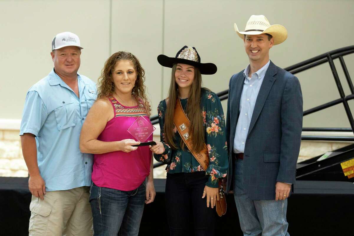 Morgan McGee, Montgomery County Fair Queen 2021, center right and MCFA Executive Committee president Cody Bartlett, right, poses for a portrait with 20-year Junior Non-Livestock auction buyers, North Montgomery County Support Group during The Montgomery County Fair Association annual Awards Dinner at the Lone Star Convention Center, Saturday, Aug. 14, 2021, in Conroe.