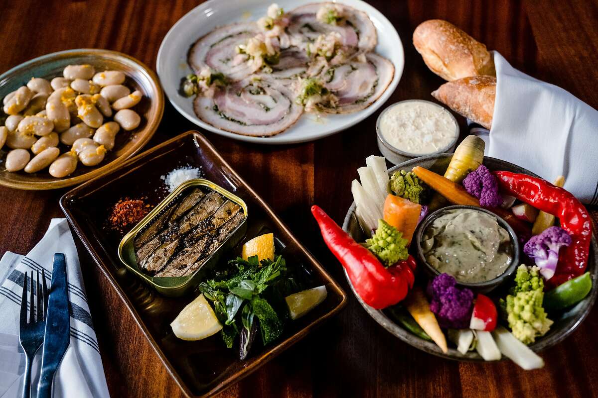Pictured from left to right Beans a la Buvette, Pork belly porchetta, Pain Deep baguette and butter, crudités and Brisling some of the food on offer at Chezchez in San Francisco on Friday, August 13, 2021.