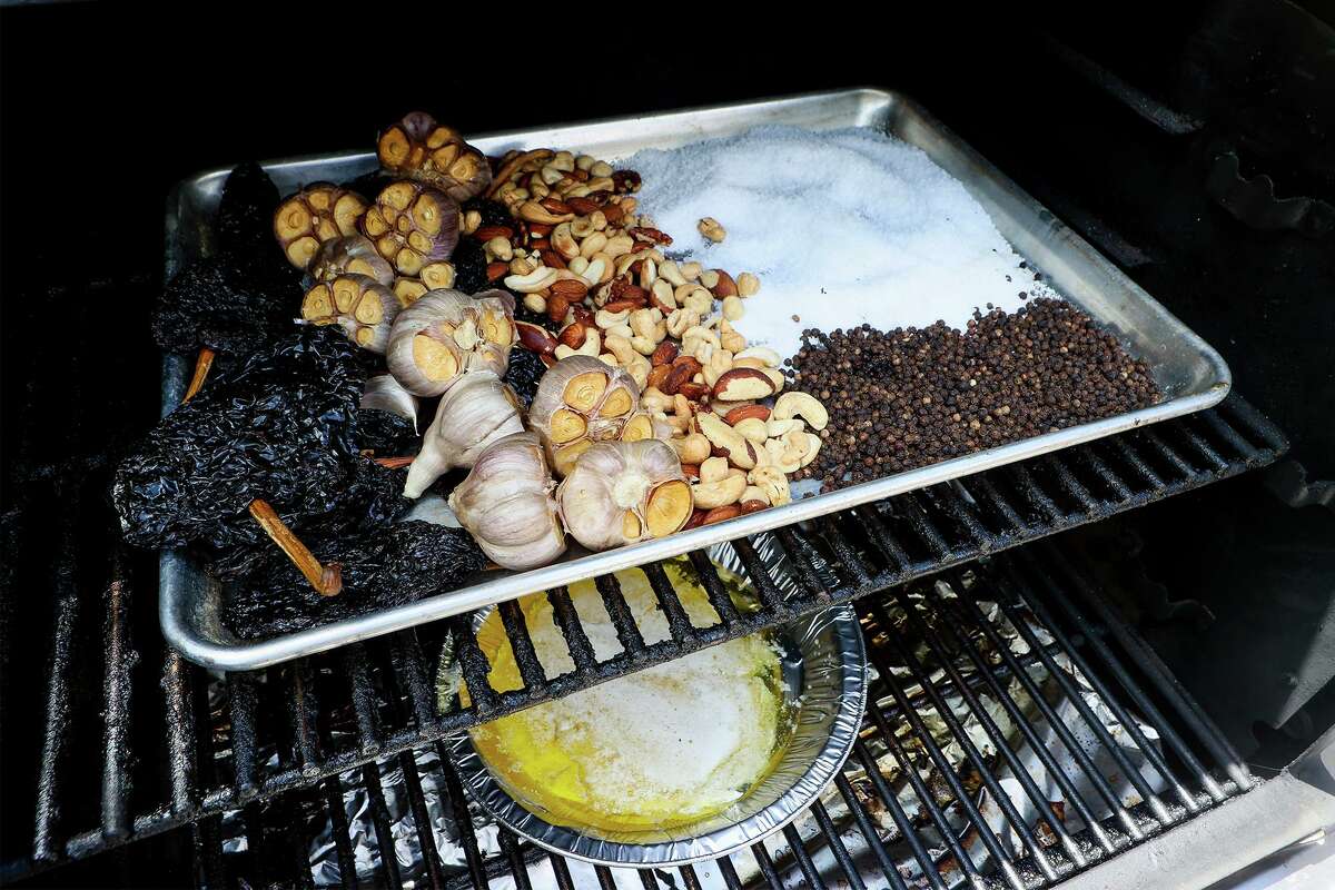 Ancho chiles, from left, whole garlic bulbs, mixed nuts, kosher salt, black peppercorn and a pan of butter, below, are just some of the ingredients that can be added to a smoker for serious flavor.