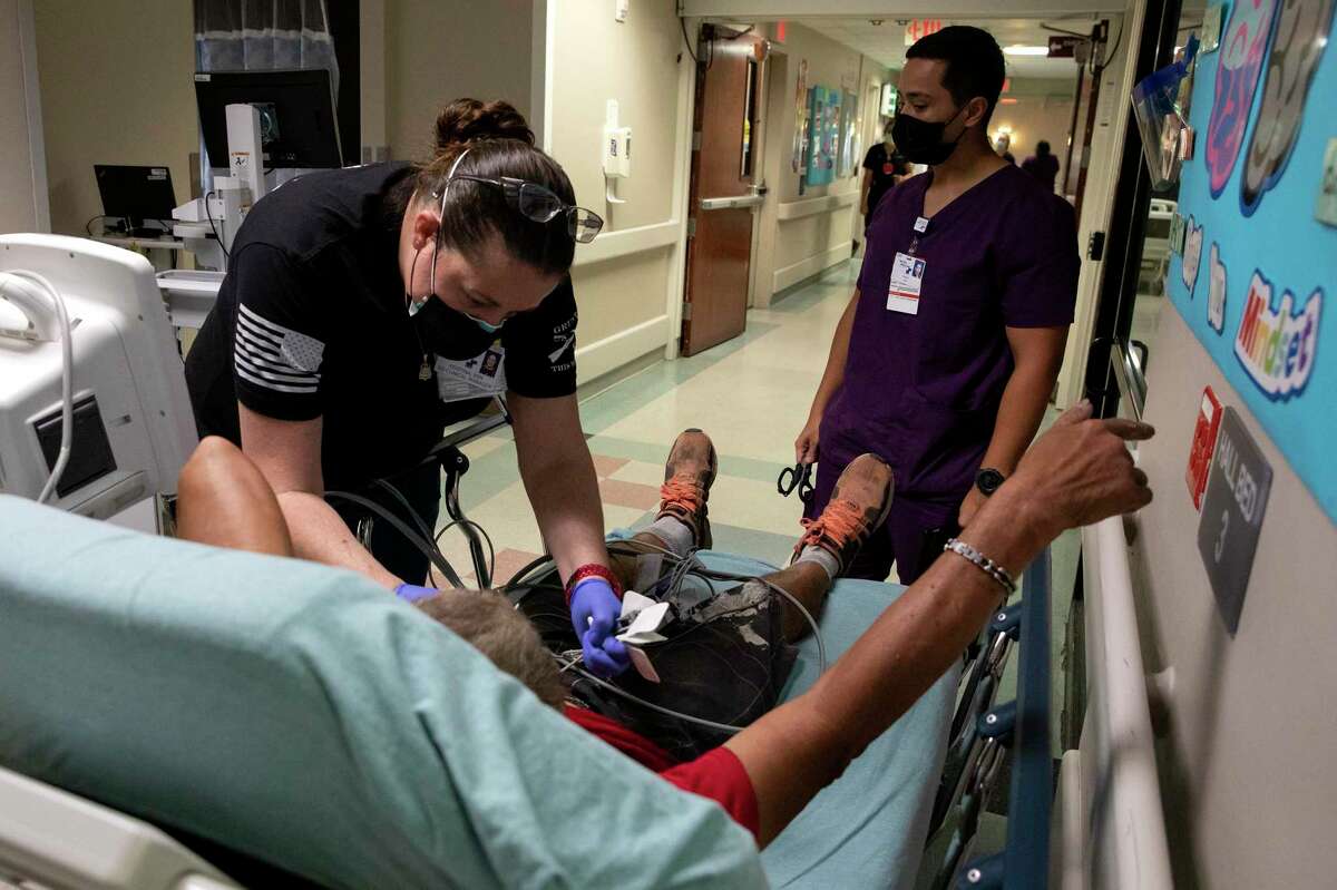 Nurse Kristina Sabo treats a patient in the emergency room hallway at Texas Vista Medical Center. The patient had to be placed there due to overcrowding from COVID-19 patients being treated in the ER.