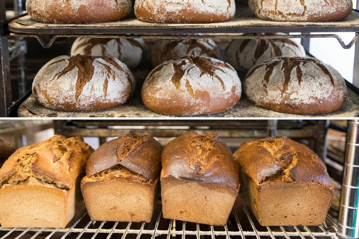Freshly baked loaves of Berlin, top, and rye bread, below, cool on racks at Cinderella Bakery and Cafe, a Russian bakery in the Richmond District of San Francisco,. on Aug. 11, 2021.