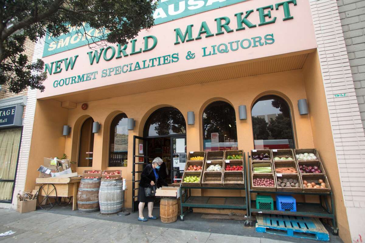 A woman looks at the produce outside New World Market in the Richmond District of San Francisco on Aug. 11, 2021.