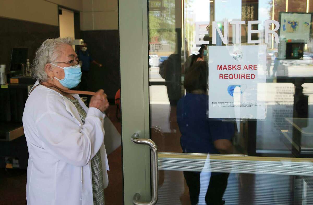 At the Cadena-Reeves Justice Center, staff and visitors are shown wearing masks on Monday, amid signs indicating that mask wearing is required. Under state law, the courts don’t fall under the governor’s orders preventing mask mandates.