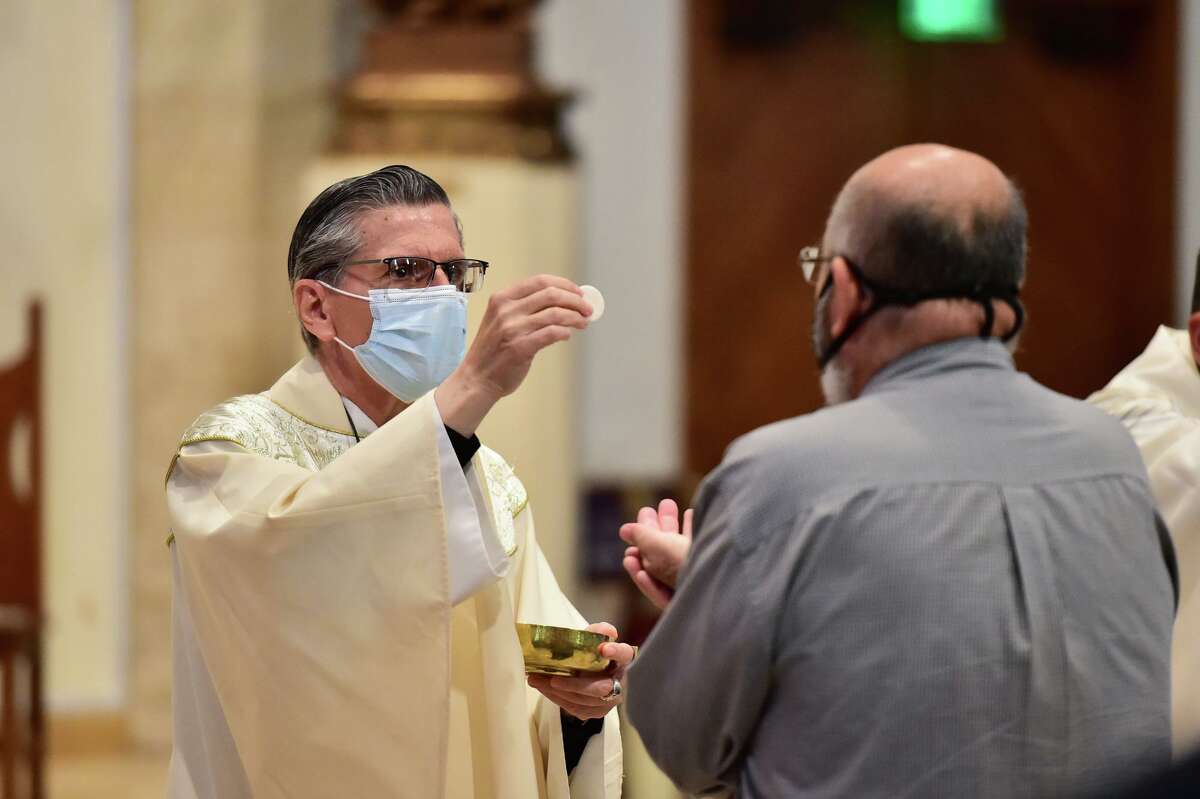 Archbishop Gustavo Garcia-Siller gives holy communion Sunday at San Fernando Cathedral.