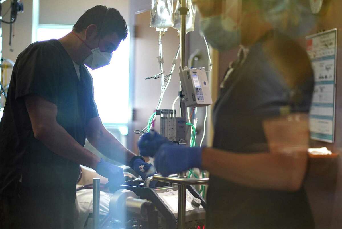 Nurses work on a COVID-19 patient, who is in his 20s, at UTMB Galveston's ICU on Wednesday, Aug. 11, 2021.