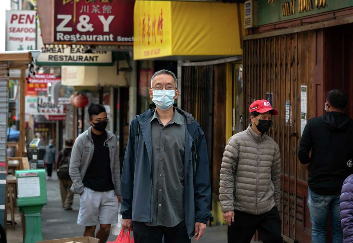 John Wang walks by former workplace Z & Y Restaurant while running errands in San Francisco's Chinatown. He was a leader in organizing workers, eventually winning a $1.61 million settlement.