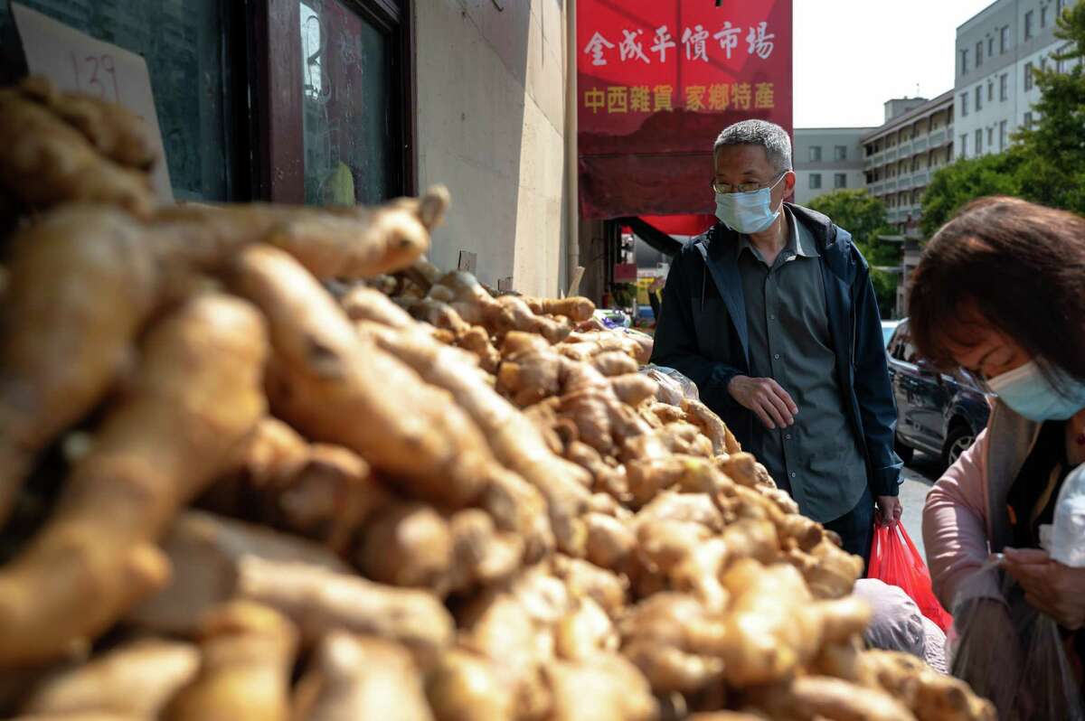 John Wang purchases groceries while running errands in San Francisco's Chinatown. Wang is a Taiwanese immigrant worker among those who spoke out against famous Sichuan restaurant Z & Y.