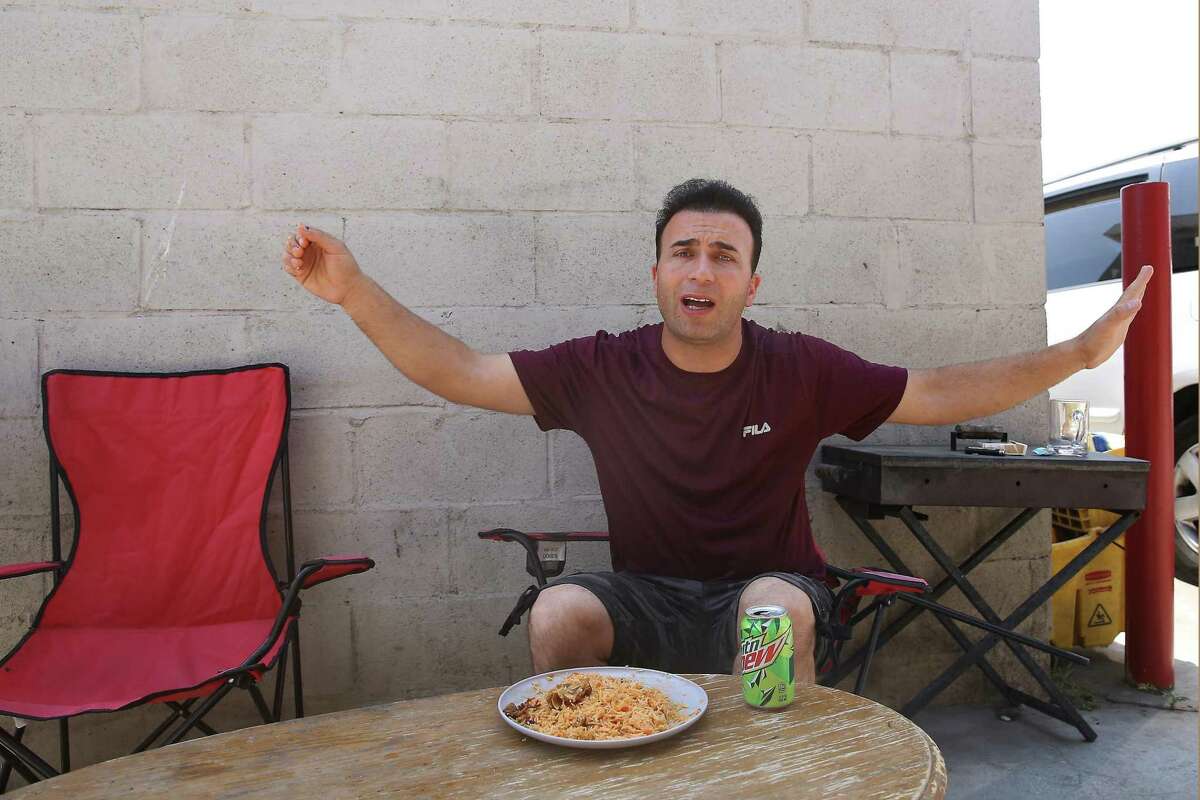 Najib Kohistani, of Fremont, reacts as he talks about his family still living in Afghanistan while eating lunch behind Khorasan Market in Fremont.
