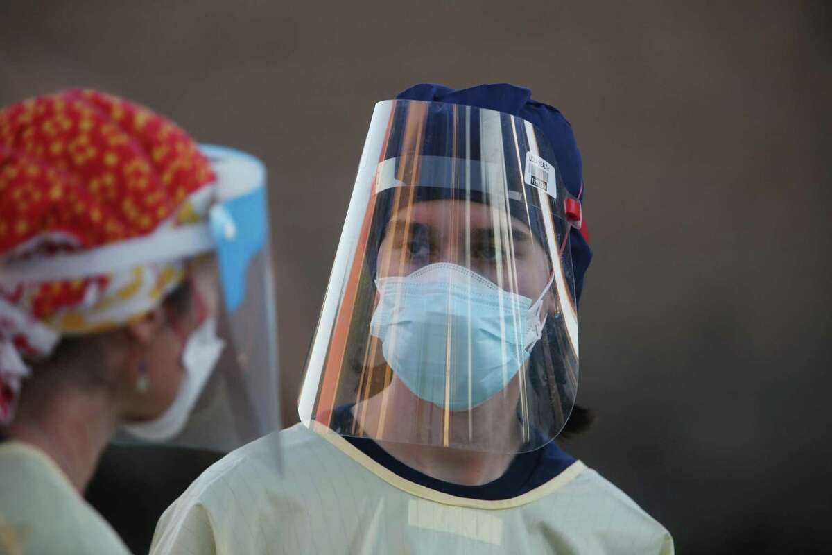 Workers at a COVID-19 test site on Armstrong at Keith Street wear face shields and masks while testing people on Friday, November 27, 2020 in San Francisco, Calif.