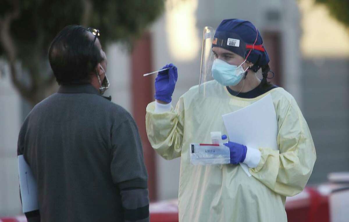A staffer at a coronavirus test site on Armstrong Avenue and Keith Street in S.F. wields a swab in November.