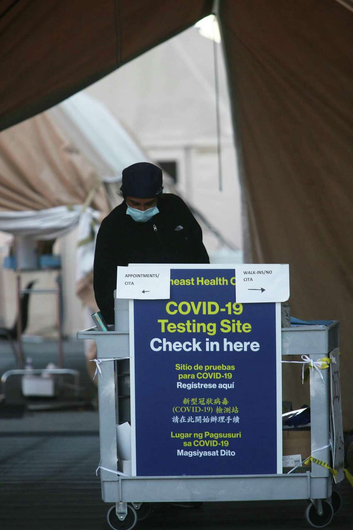 A staff member stands by a check in station at a COVID-19 test site on Armstrong at Keith Street on Friday, November 27, 2020 in San Francisco, Calif.