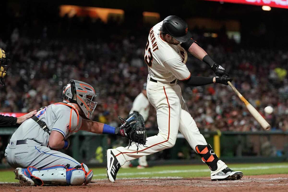 San Francisco Giants' Kris Bryant, right, hits a two-run home run in front of New York Mets catcher James McCann during the fifth inning of a baseball game in San Francisco, Monday, Aug. 16, 2021. (AP Photo/Jeff Chiu)