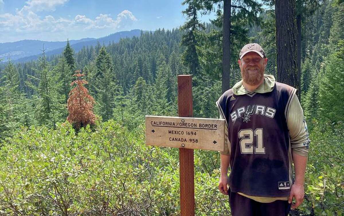 Since April 9, Brian Sporer has been hiking the Pacific Crest Trail while wearing a Tim Duncan jersey. Here he crosses into Oregon after hiking almost 1,700 miles through California.