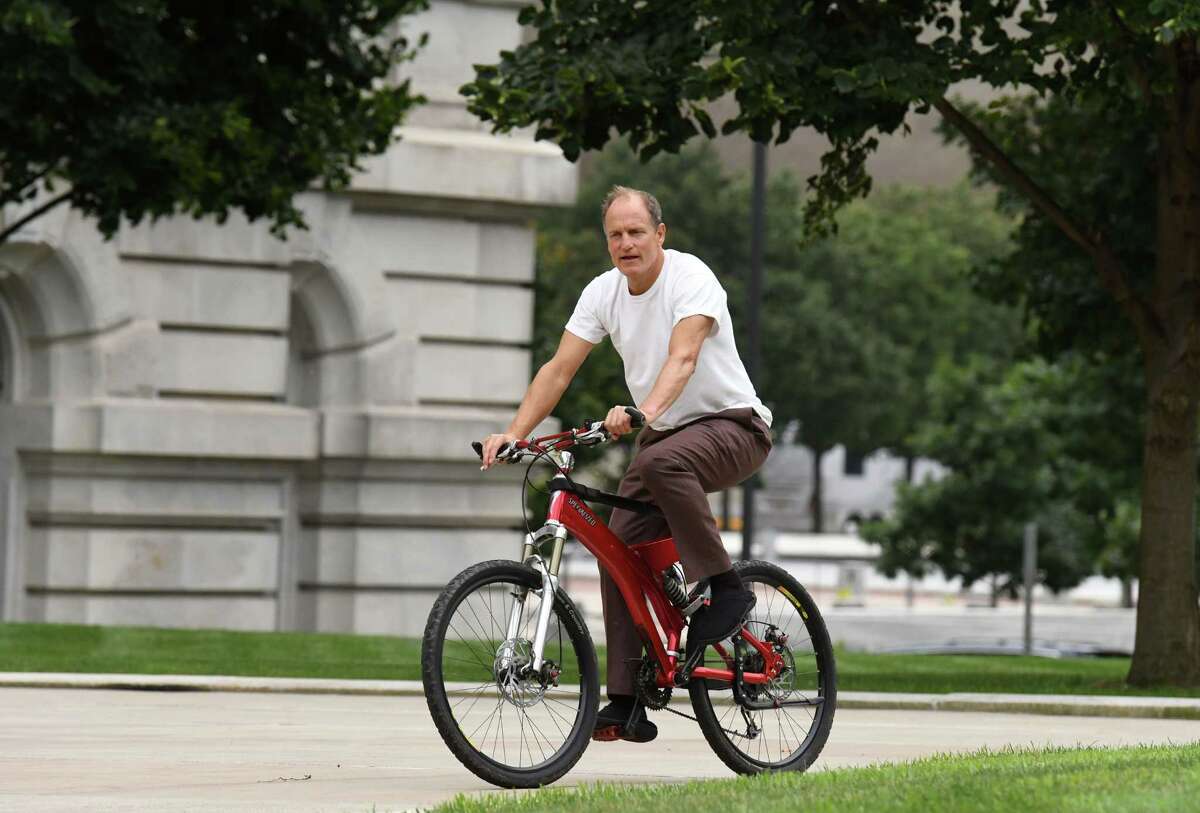 Actor Woody Harrelson rides back to his trailer across West Capitol Park after rehearsing a scene in the Legislative Office Building for HBO's 'The White House Plumbers' on Tuesday, Aug. 17, 2021, in Albany, N.Y. The series chronicles the story of the Watergate masterminds.