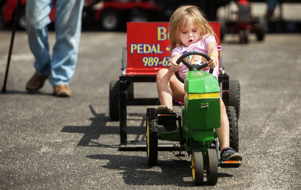 Brynleigh Flesner of Midland, 4, pedals away on a miniature tractor during the children's pedal pull contest Tuesday, Aug. 17, 2021 at the Midland County Fair. (Katy Kildee/kkildee@mdn.net)