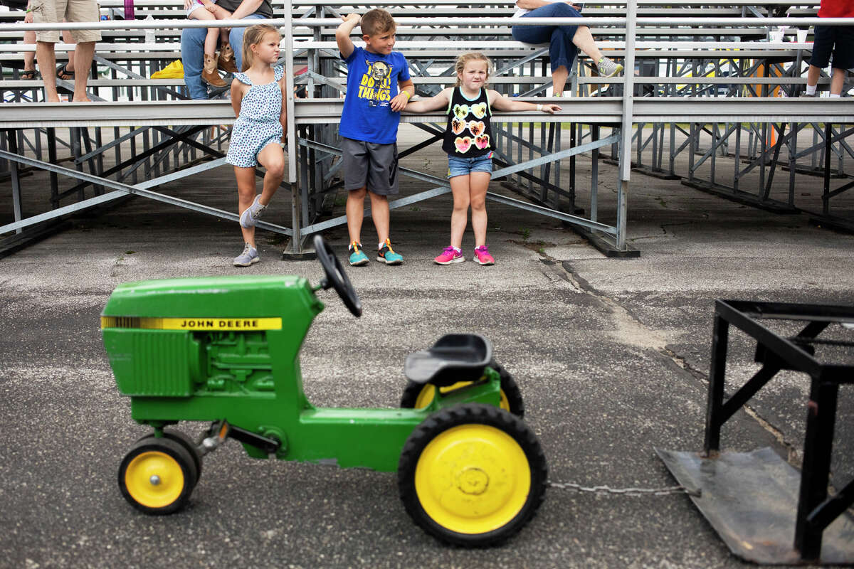 Kids take turns seeing how far they can pedal a miniature tractor during the children's pedal pull contest Tuesday, Aug. 17, 2021 at the Midland County Fair. (Katy Kildee/kkildee@mdn.net)