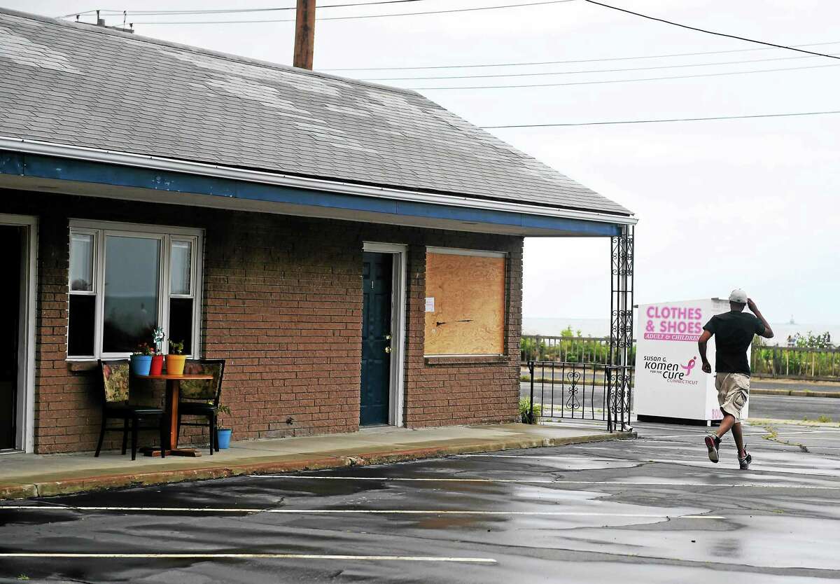 A person at the partially condemned Debonair Beach Motel in West Haven walks toward Beach Street July 27, 2014.