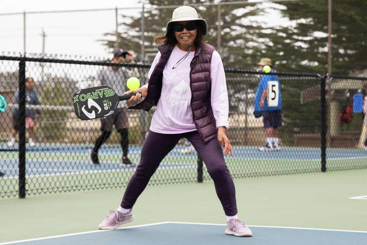 Carmen Reyes serves while playing pickleball at the courts near Louis Sutter Playground in McLaren Park.