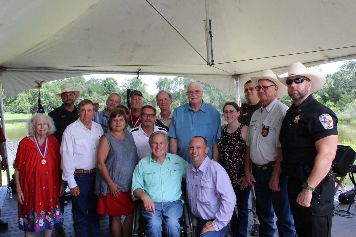 Gov. Greg Abbott poses with a group at an event in Austin County on Aug. 7, 2021.