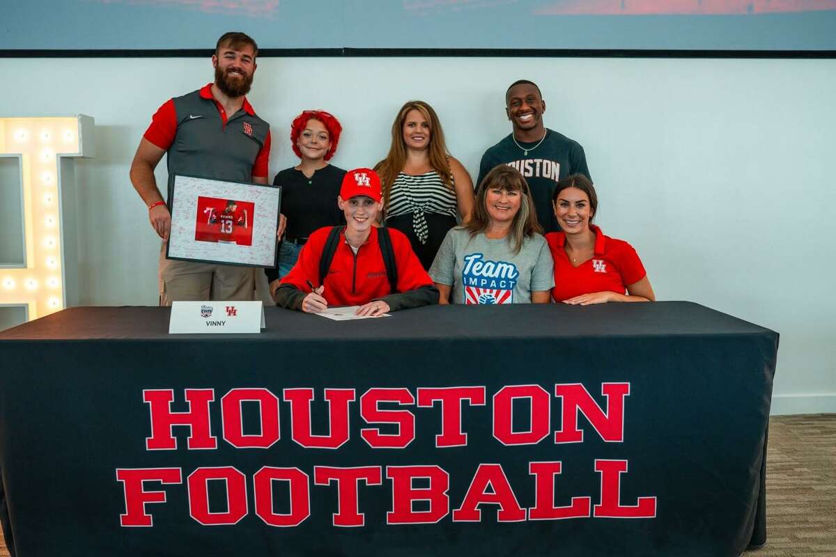 Vinny Robins, front left, signs his honorary national letter of intent with the UH football program on July 22, less than three weeks before dying of colorectal cancer.