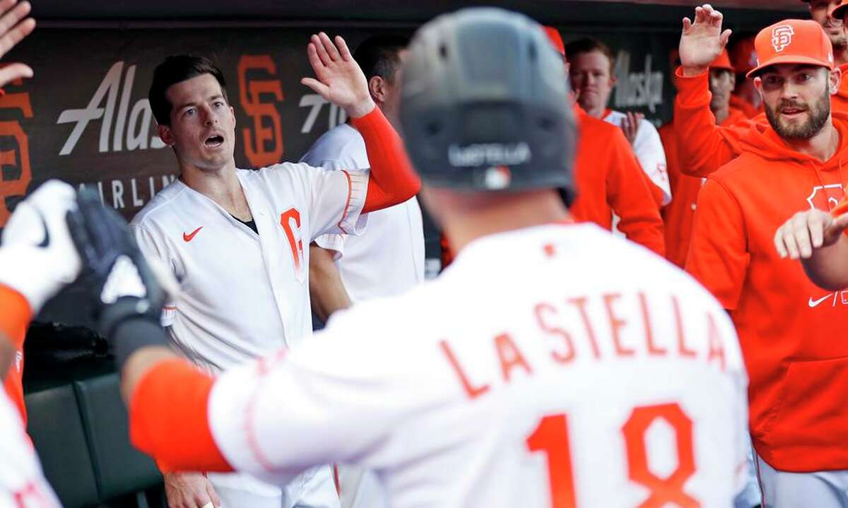 Giants infielder Tommy La Stella gets a hearty dugout welcome from teammates after a home run against the Mets.