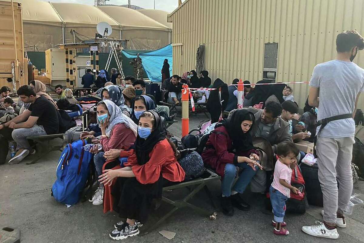 People wait to be evacuated from Afghanistan at the airport in Kabul on Aug. 18, 2021, following the Taliban takeover of the country.