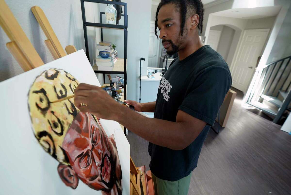 SMU defensive back RaSun Kazadi works on a painting at his apartment Wednesday, Aug. 11, 2021, in Dallas. A junior, Kazadi, who goes by the first name Ra, has been painting only since high school. Some works are lighthearted and fun. Some were done as stress relief. Others reflect a certain point in his life. He also runs a separate non-profit group to promote social justice and community conflict resolution.