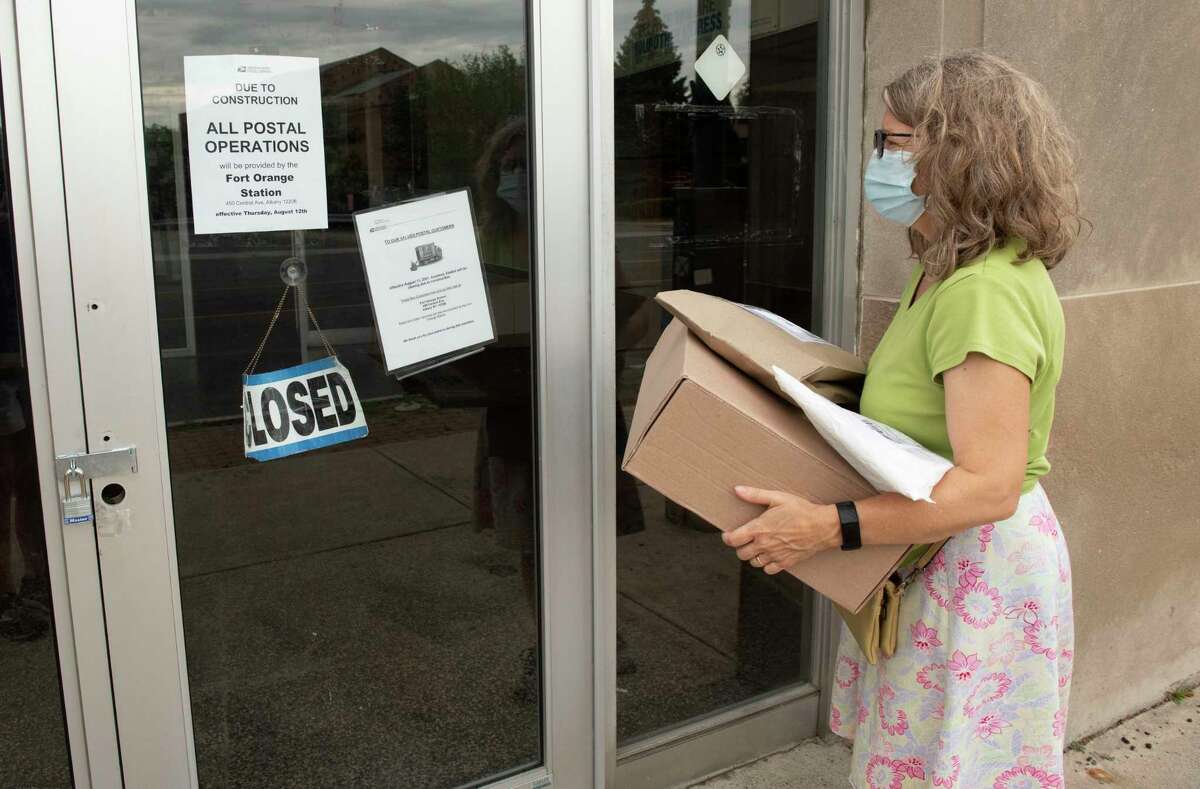 Nancy Perini of Albany sadly reads the signs posted on the door of the closed post office at 563 New Scotland Ave. on Wednesday, Aug. 18, 2021 in Albany, N.Y. She was hoping to get to the post office before it closed and was surprised to see it my be closed for good.