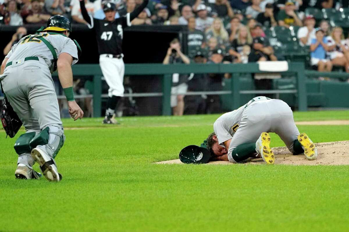 Oakland Athletics catcher Sean Murphy runs to starting pitcher Chris Bassitt after Bassitt was hit in the head from a ball hit by Chicago White Sox's Brian Goodwin during the second inning of a baseball game, Tuesday, Aug. 17, 2021, in Chicago. (AP Photo/Charles Rex Arbogast)