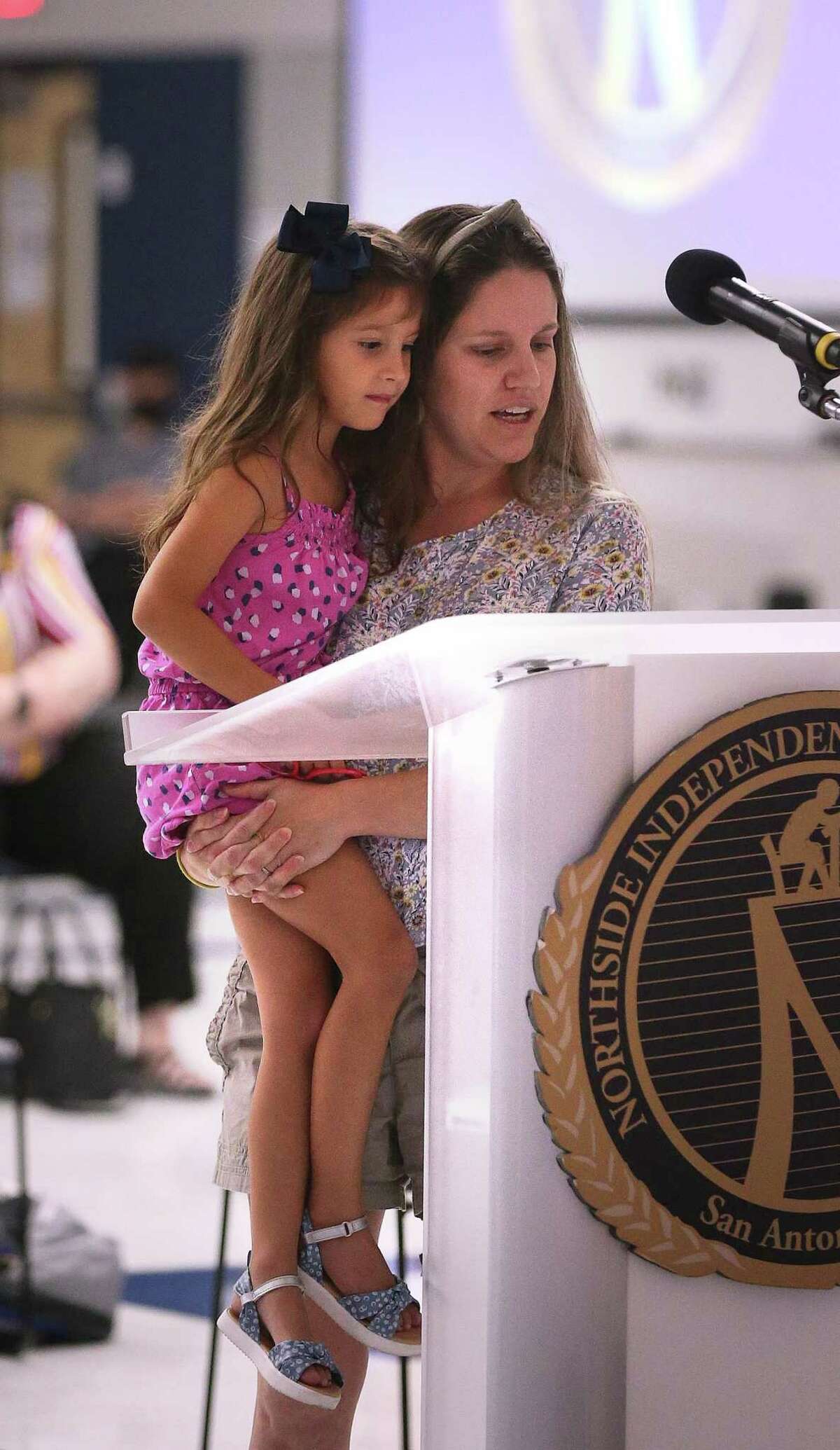 At Northside ISD’s board meeting, Lesley Casias reads with her daughter Irelynn, 5, the letter she wrote last night on why they should not mandate wearing a mask.
