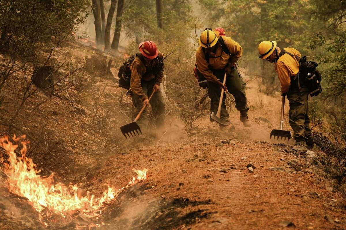 Firefighters work to contain a control burn to prevent the fire line from reaching the structures situated on North Arm Road during the Dixie Fire near Taylorsville, Calif., on on Aug. 15.