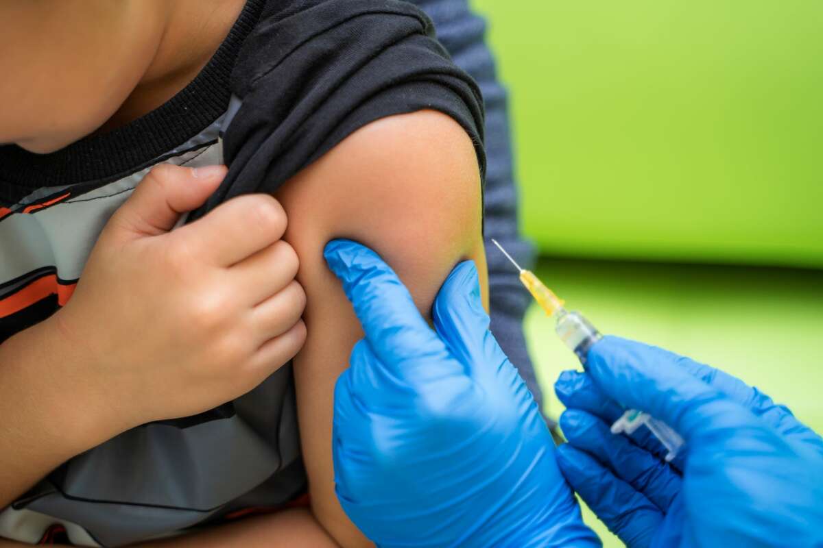 Pediatrician prepares to vaccinate a young boy.