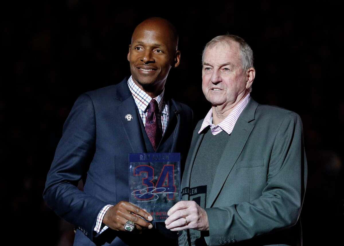 Hall of Famer Ray Allen, left, is presented with a plaque by coach Jim Calhoun, right, in a halftime ceremony during which Allen's number was retired on March 3, 2019, in Storrs.