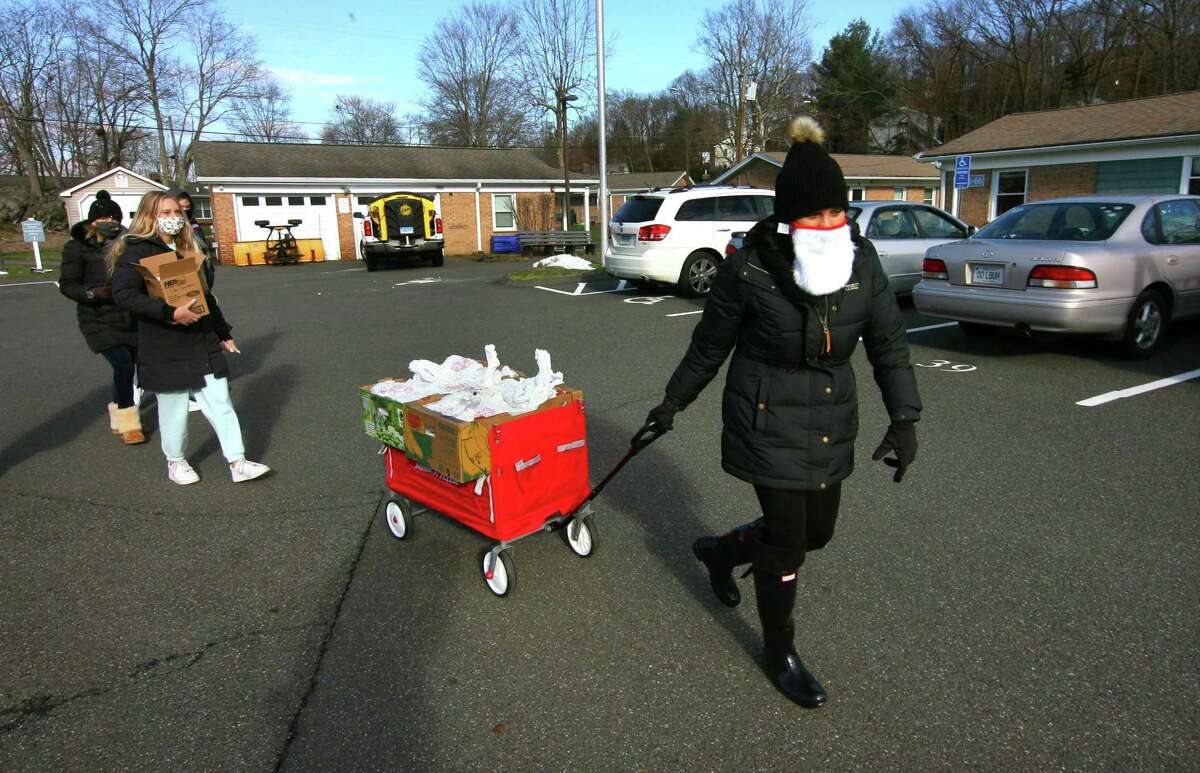 New American Dream Foundation Vice President Emanuela Palmares arrives with volunteers to deliver meals to senior citizens at Glen Apartments in Danbury, Conn., on Saturday Dec. 26, 2020. Ticket sales from the gala benefit the meals program.