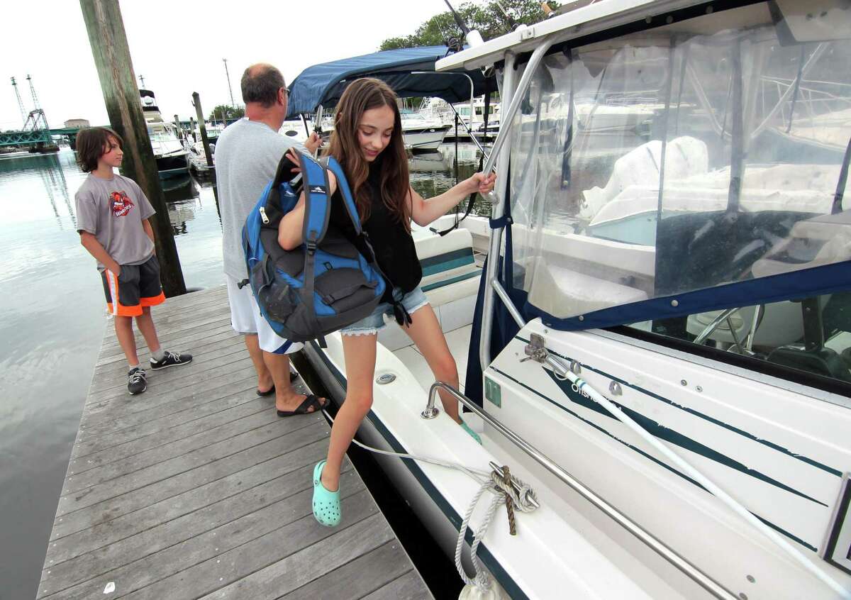 Robert Kylie Bernhard, 11, disembarks the family boat after returning ffrom some fishing on the family boat at Palmer Point Marina in Greenwich, Conn., on Friday August 20, 2021. The region will be bracing for Hurricane Henri, which is expected to hit Connecticut over the weekend causing coastal flooding and wind gusts up to 60 mph.