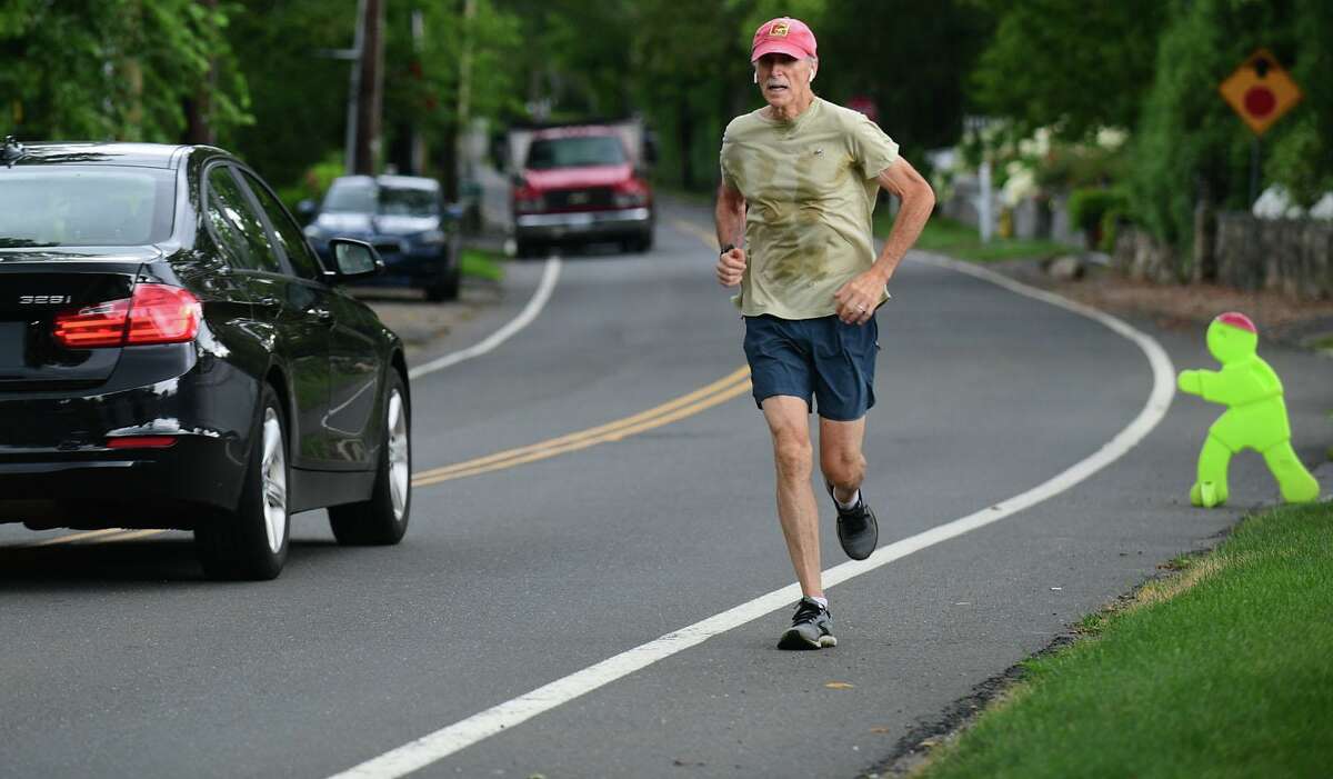 A jogger runs along Shore Road Thursday, August 19, 2021, in Greenwich, Conn. Resident Maggie Bound is leading a community effort to demand town action on what she considers to be a very dangerous intersection in Old Greenwich.