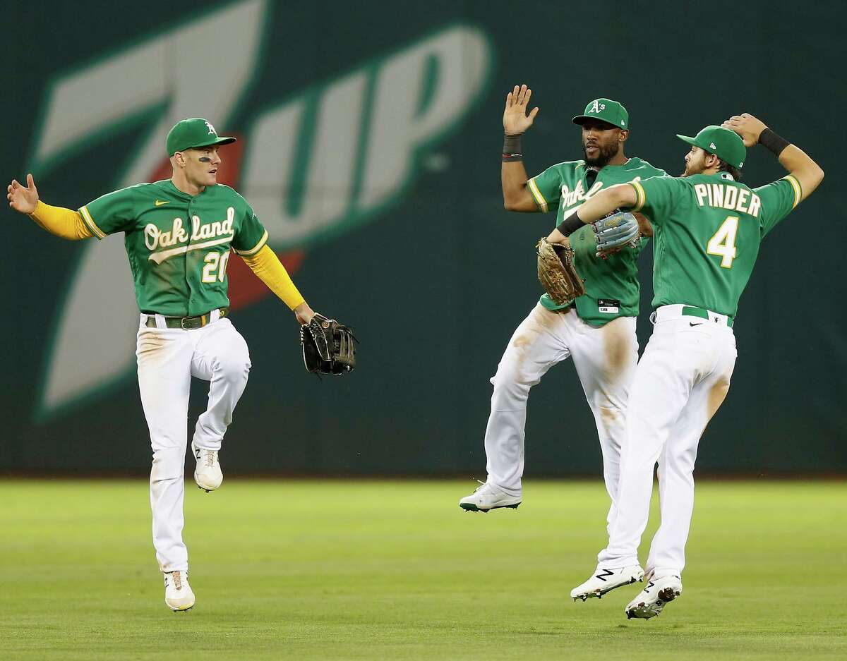 Outfielders Mark Canha (left) Starling Marte and Chad Pinder celebrate the A’s win over the Giants in Oakland.