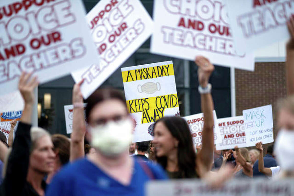 People in favor of and against a mask mandate for schools protest ahead of a school board meeting in Marietta, Georgia.