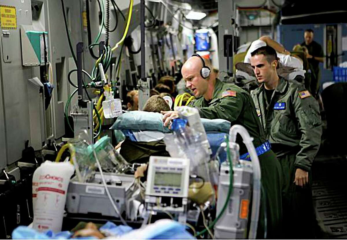 Capt. Darrell W. Saylor (left) and Staff Sgt. Brett Anderson, part of a critical care and transport team, tend to the critically wounded who are being flown from Ramstein Air Base in Germany to Andrews Air Force Base in Maryland.